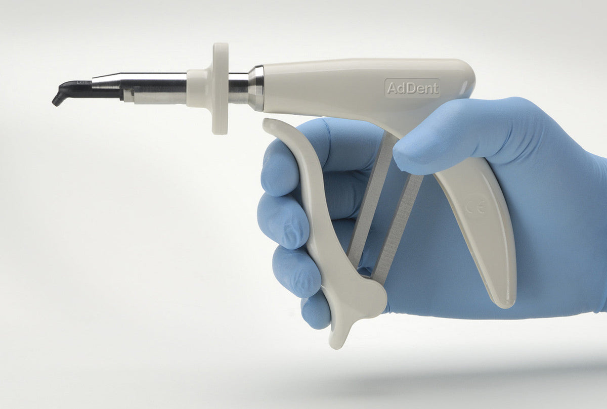 AdDent CoMax composite dispenser in a dentist's hand