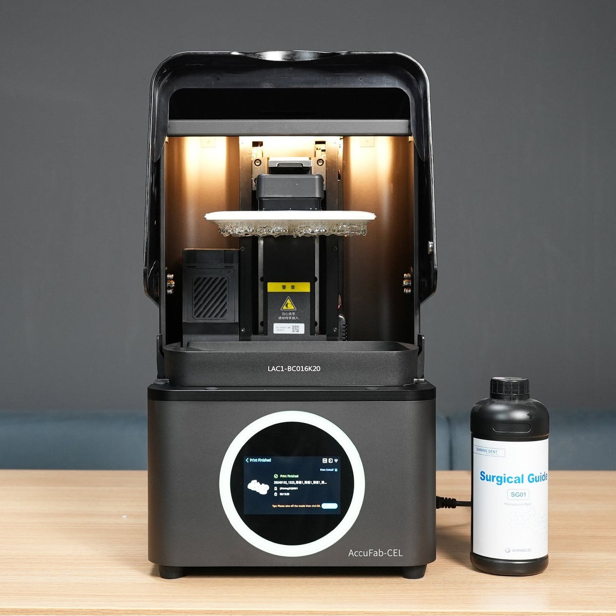 AccuFab-CEL printer on a workbench next to a resin bottle